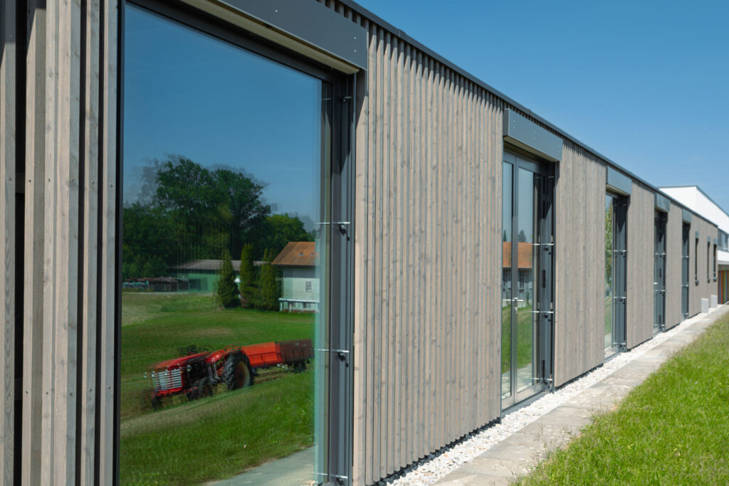 Façade en bois de l’école primaire de Lossy réalisée par Stauffacher Charpentes SA.
