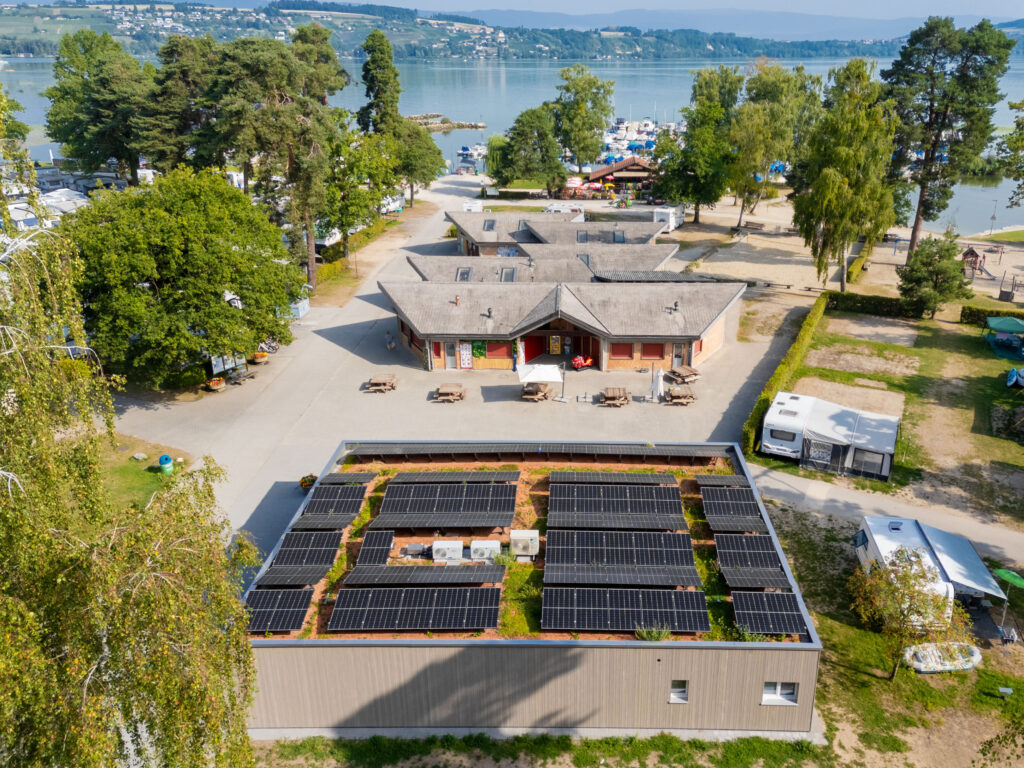 Luftaufnahme des Camping Plage in Avenches mit Solaranlage auf dem Dach.